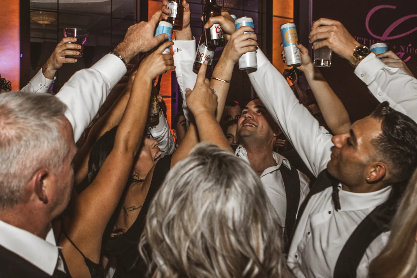 Wedding guests raising a toast together on the dance floor